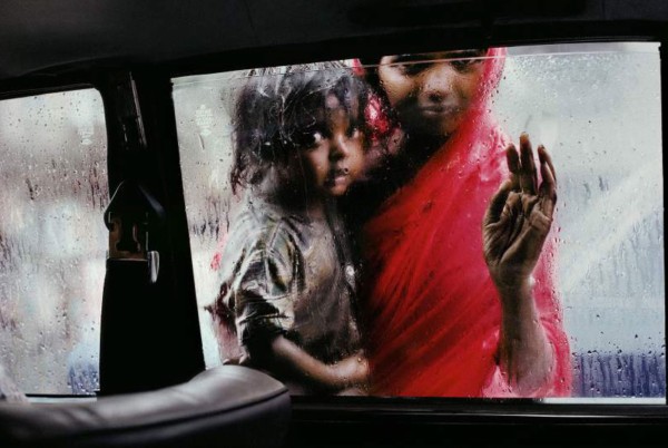 Steve McCurry "Während des Monsuns bittet eine Frau mit Kind um eine Zuwendung am Autofenster", Mumb