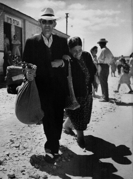 Robert Capa "Man and woman carrying their belongings in sacks, Haifa, Israel", 1949