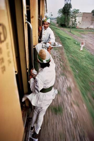 Steve McCurry "Frühstückstee wird zwischen den Zugwaggons weitergereicht", Peschawar, Pakistan 1983